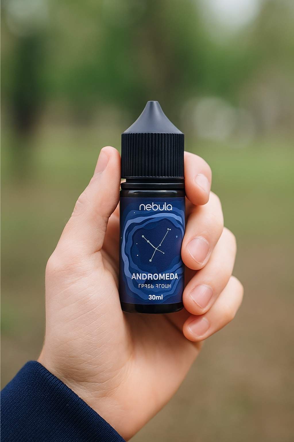 Флакон лінійки Nebula у руці вейпера, крупний план